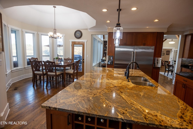 kitchen featuring pendant lighting, a center island with sink, dark wood-type flooring, and high end refrigerator