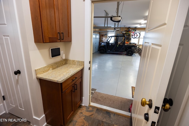 kitchen with dark tile floors and light stone counters