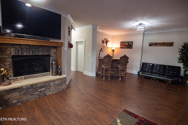 living room with dark hardwood / wood-style flooring, ornamental molding, a stone fireplace, and a textured ceiling