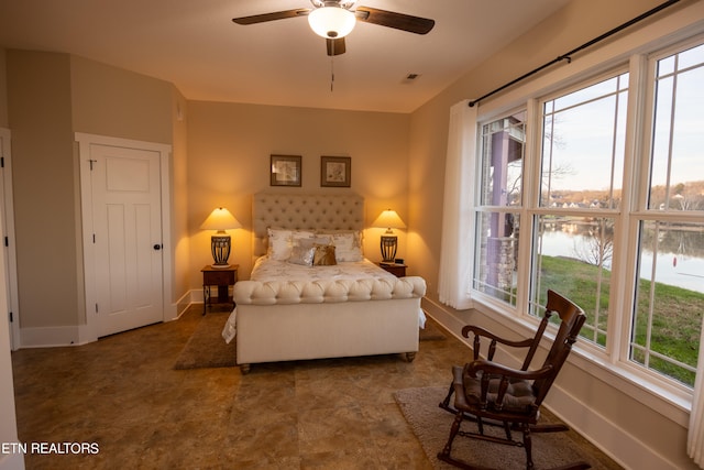 bedroom featuring ceiling fan, a water view, and dark tile flooring