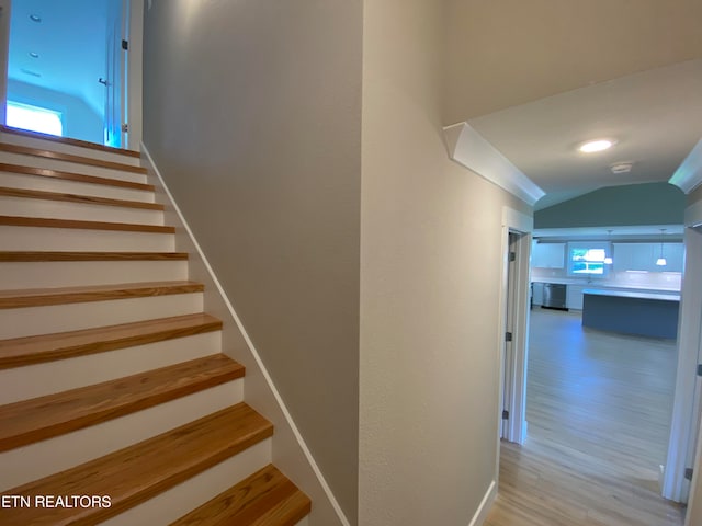 stairway featuring hardwood / wood-style floors and vaulted ceiling