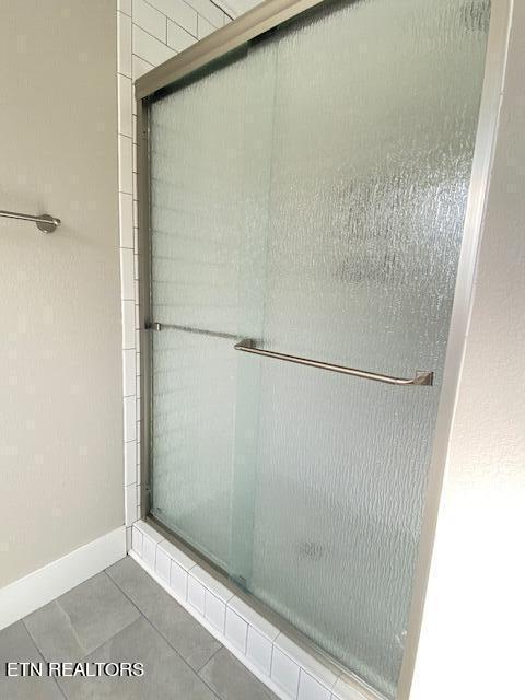 bathroom with tile patterned floors and an enclosed shower