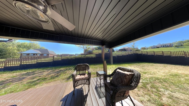 wooden terrace with ceiling fan and a yard