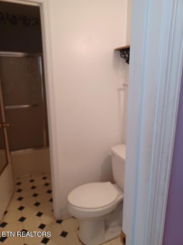 bathroom with tile flooring and toilet