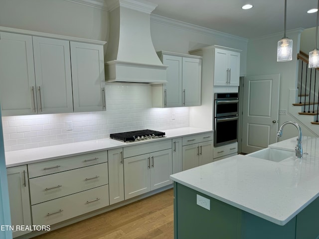 kitchen featuring crown molding, stainless steel appliances, sink, and custom exhaust hood