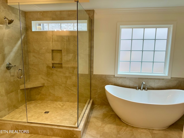 bathroom featuring ornamental molding and separate shower and tub