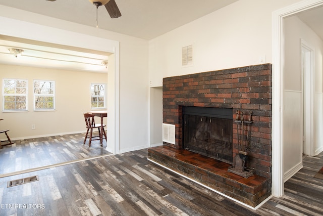 unfurnished living room featuring ceiling fan, dark wood-type flooring, and a fireplace