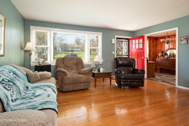 living room featuring a notable chandelier and light wood-type flooring