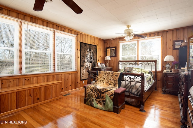 bedroom featuring wood walls and light hardwood / wood-style floors