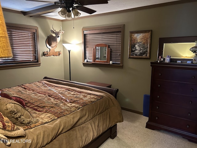 bedroom featuring ceiling fan, light colored carpet, and a textured ceiling