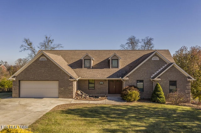 view of front of property with a front yard, brick siding, driveway, and an attached garage