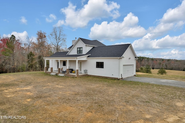 view of front of property with a front lawn, a porch, and a garage