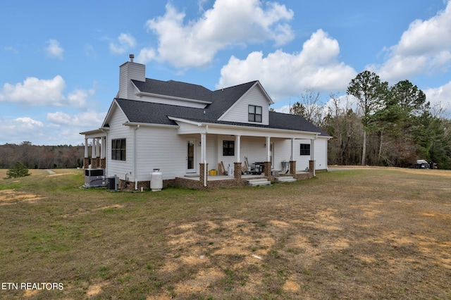 rear view of house with central AC, a yard, and a porch