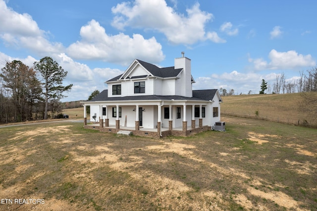 farmhouse inspired home featuring a front yard, central AC unit, and a porch