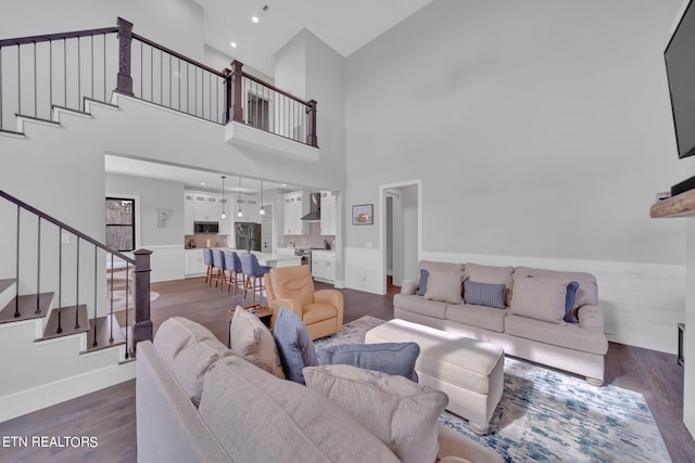 living room with a high ceiling and dark hardwood / wood-style floors