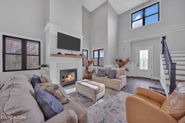 living room with a notable chandelier, a high ceiling, and hardwood / wood-style flooring