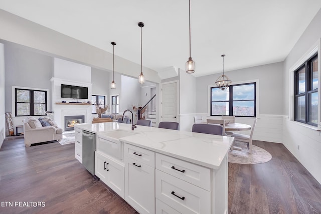 kitchen featuring white cabinetry, a center island with sink, dark hardwood / wood-style floors, pendant lighting, and dishwasher