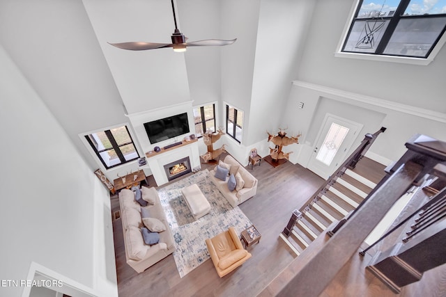 living room featuring a towering ceiling, ceiling fan, and dark hardwood / wood-style floors