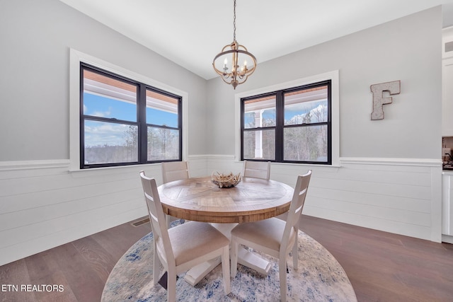 dining space with a chandelier and dark wood-type flooring