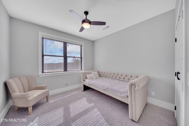 living area with ceiling fan and light colored carpet