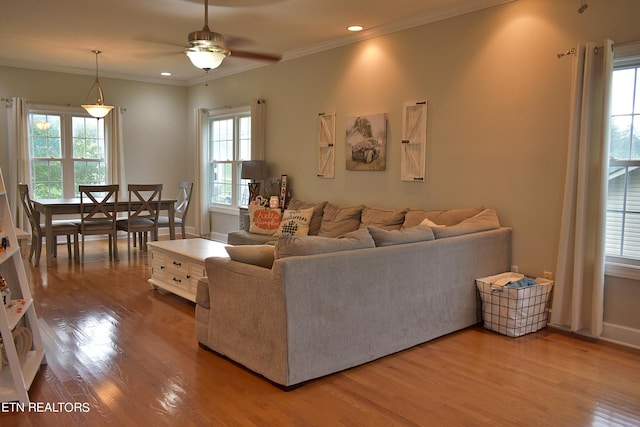 living area with recessed lighting, crown molding, and wood finished floors