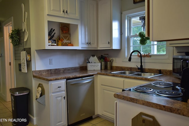 kitchen featuring light tile patterned floors, white cabinetry, stainless steel appliances, backsplash, and sink