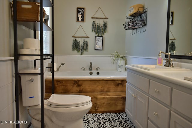 full bathroom featuring a garden tub, tile patterned flooring, toilet, a wainscoted wall, and vanity