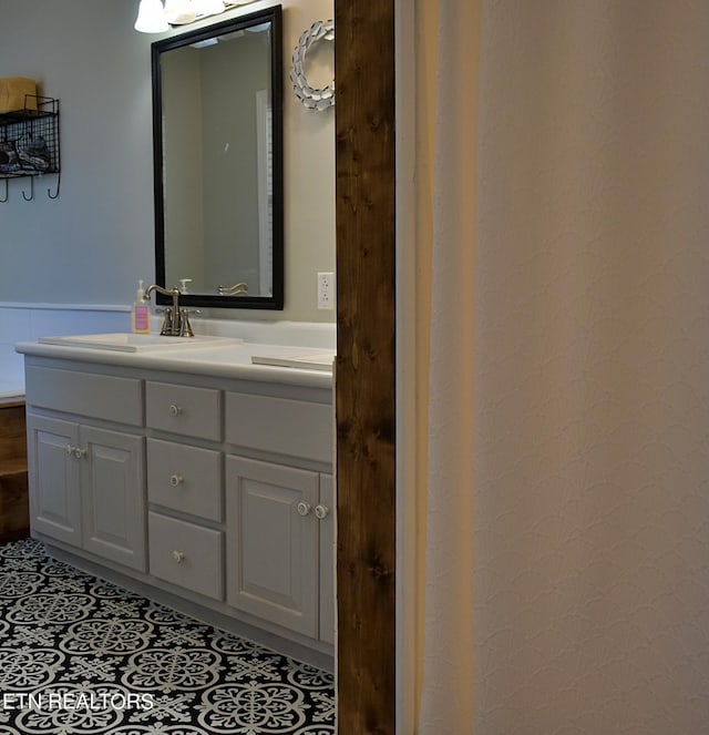 bathroom with tile patterned floors, a wainscoted wall, and vanity