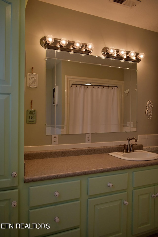 bathroom featuring walk in shower and vanity