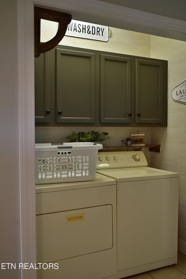 laundry area with cabinet space, washer and clothes dryer, and light tile patterned flooring