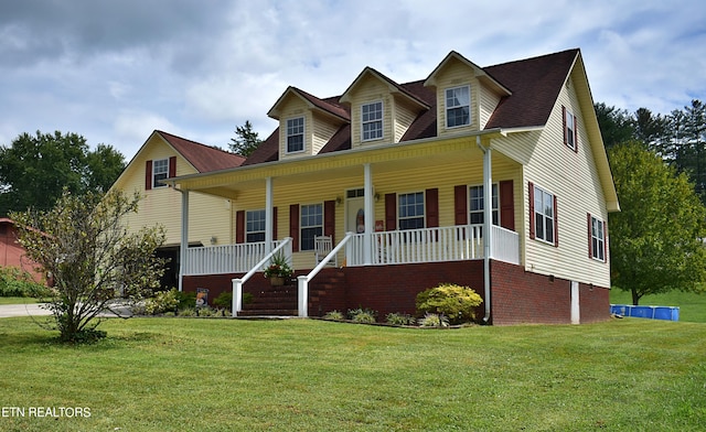 cape cod house with a front yard and a porch