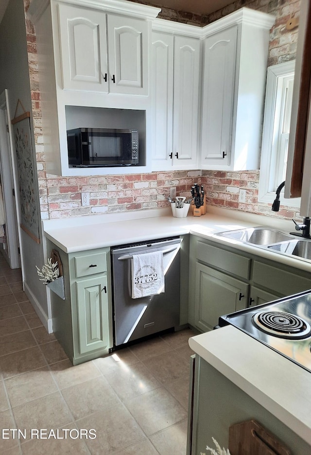 kitchen with light countertops, stainless steel dishwasher, a sink, and white cabinetry