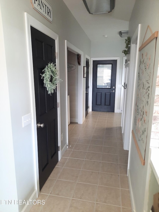 interior space with light tile patterned floors and baseboards