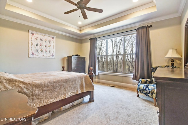 carpeted bedroom featuring ceiling fan, a tray ceiling, and crown molding