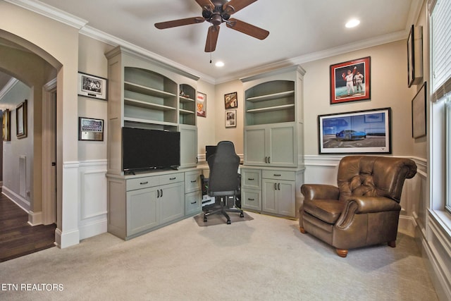 carpeted home office with ceiling fan, built in features, and ornamental molding