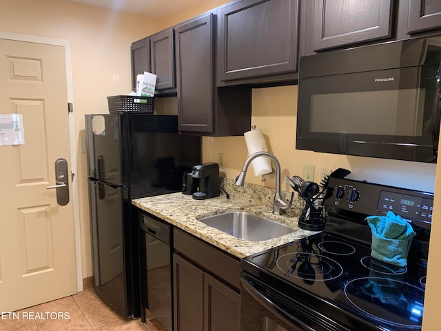 kitchen featuring light stone countertops, black appliances, light tile flooring, sink, and dark brown cabinetry