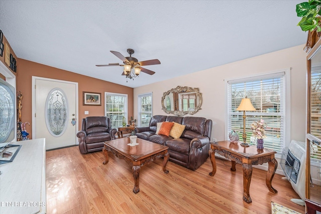 living room with lofted ceiling, light hardwood / wood-style floors, ceiling fan, and a healthy amount of sunlight