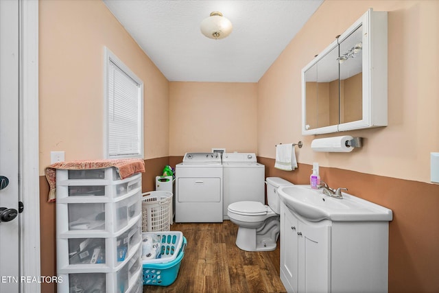 bathroom featuring hardwood / wood-style floors, washer and dryer, toilet, and vanity