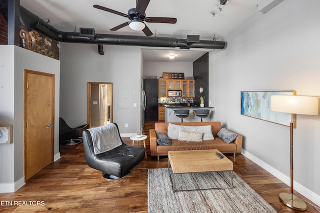 living room featuring rail lighting, dark hardwood / wood-style flooring, and ceiling fan