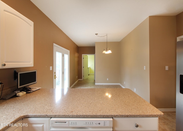 kitchen with an inviting chandelier, light stone counters, white dishwasher, light tile patterned flooring, and decorative light fixtures