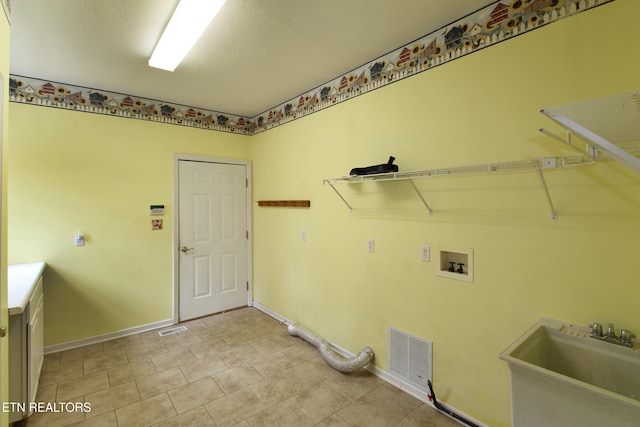 laundry room with sink, hookup for a washing machine, and a textured ceiling