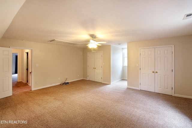 carpeted spare room with ceiling fan