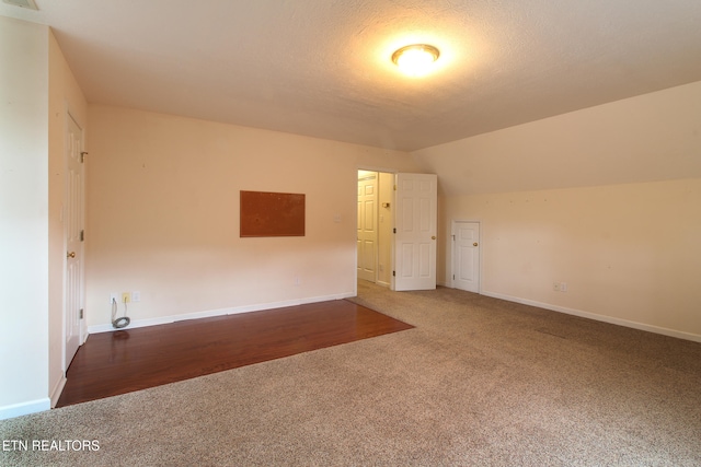 carpeted spare room featuring vaulted ceiling