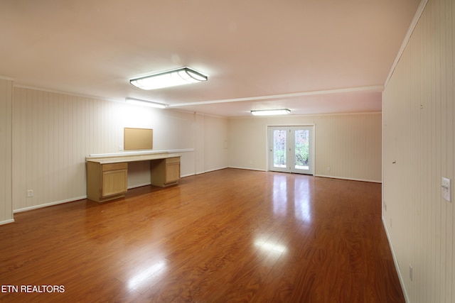 empty room with french doors, crown molding, and hardwood / wood-style flooring