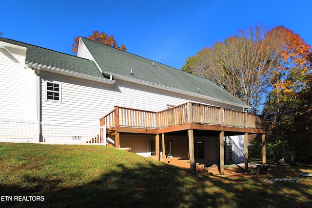 back of house featuring a deck and a lawn