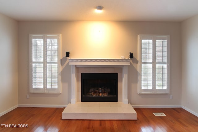 interior details with wood-type flooring and a fireplace