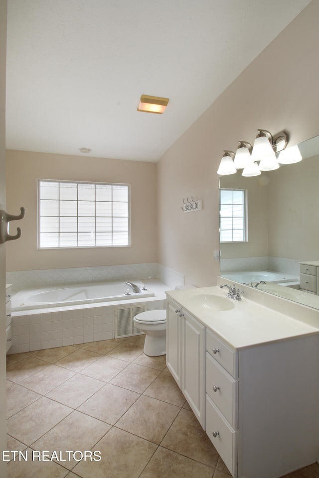 bathroom featuring vanity, tiled tub, tile patterned flooring, and toilet