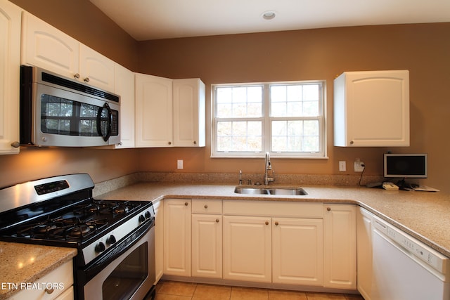 kitchen with white cabinetry, appliances with stainless steel finishes, sink, and light tile patterned flooring