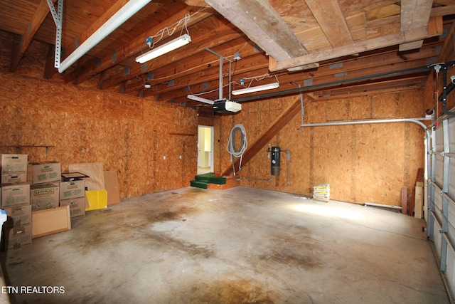 garage featuring a garage door opener and wood walls