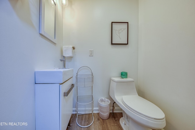 bathroom featuring vanity, hardwood / wood-style floors, and toilet